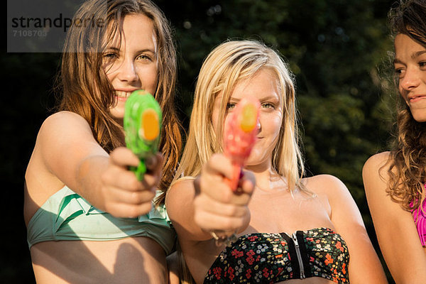 Mädchen zielen mit Wasserpistolen auf die Kamera