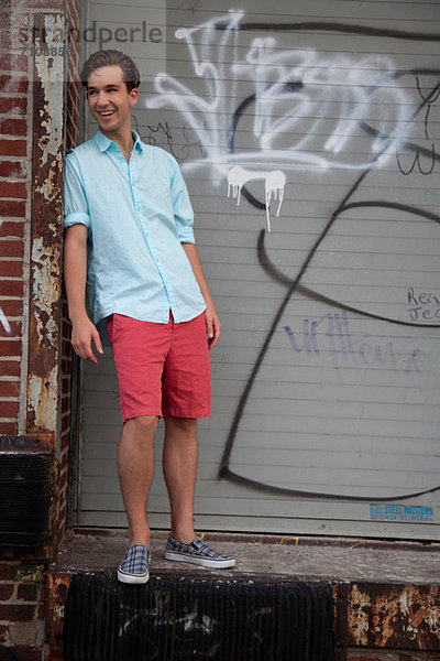 Junger Mann steht vor Graffiti  Porträt
