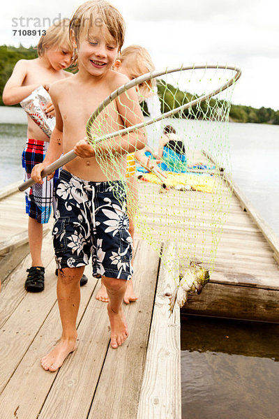 Junge mit Frosch im Fischernetz