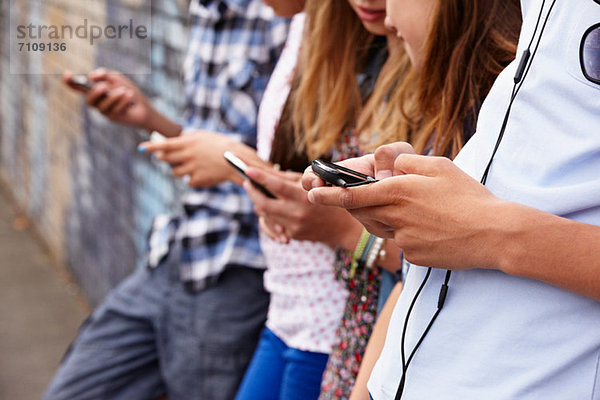 Jugendliche  die Mobiltelefone benutzen