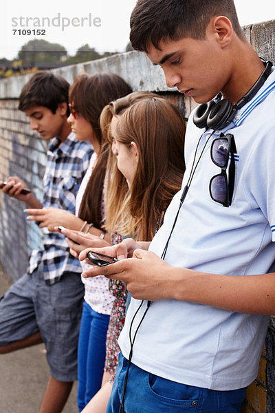 Jugendliche  die Mobiltelefone benutzen