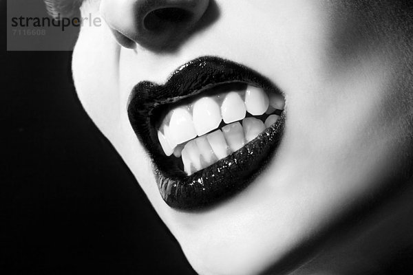 Junge Frau beißt ihre Zähne zusammen  close-up mund