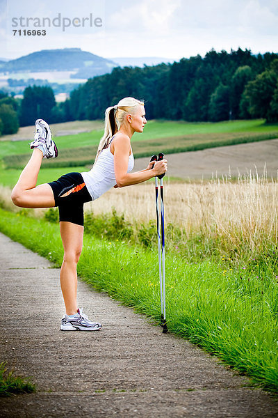 Junge Frau beim Stretching  Nordic Walking
