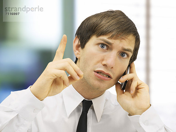 Telefonierender Geschäftsmann  Portrait  gestresst  mahnende Geste  mit erhobenem Zeigefinger