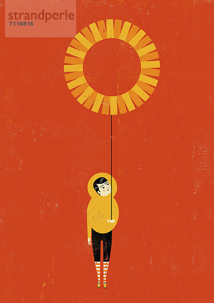 Junge hält einen Sonnen-Ballon