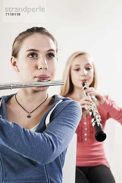 Zwei Teenagerinnen spielen Oboe und Querflöte
