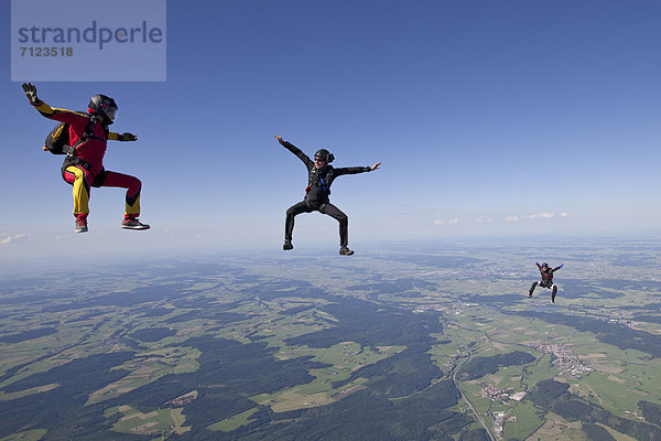 Drei Fallschirmspringer in der Luft  Bayern  Deutschland