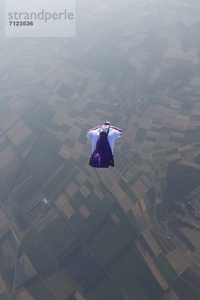 Fallschirmspringer mit Wingsuit in der Luft  Waadt  Schweiz