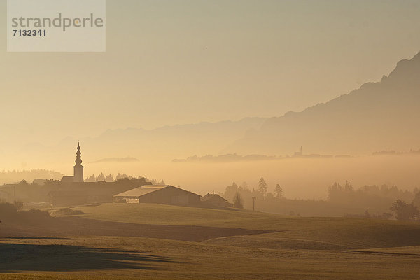 Ländliches Motiv  ländliche Motive  Europa  Vertrauen  Sonnenaufgang  Rauch  Landwirtschaft  Nebel  Kirche  Religion  Dorf  Kirchturm  Herbst  Soße  Bayern  Stimmung  Oberbayern