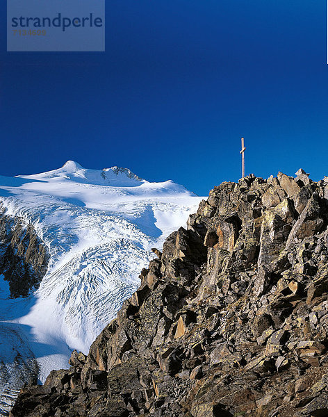 entfernt  hoch  oben  durchsichtig  transparent  transparente  transparentes  überqueren  Europa  Berg  Berggipfel  Gipfel  Spitze  Spitzen  Sonnenstrahl  Urlaub  Morgen  Beleuchtung  Licht  Himmel  Steilküste  weiß  Eis  Natur  blauer Himmel  wolkenloser Himmel  wolkenlos  blau  Ansicht  Morgendämmerung  Tirol  Österreich  Kreuz  Distanz  Stubaital  Gipfelkreuz  Sonne