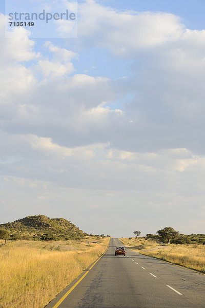 Hochformat  Auto  Landschaft  fahren  Fernverkehrsstraße  Bundesstraße  rot  Namibia  Afrika  Savannah