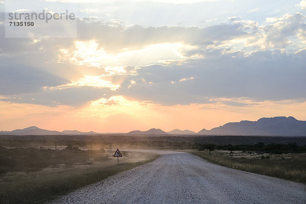 Berg  Sonnenuntergang  Morgen  Silhouette  Himmel  Sonnenaufgang  Fernverkehrsstraße  Schotterstrasse  Straßenschild  Namibia  Wiese  Namib  Afrika  Abenddämmerung  Savannah  Sossusvlei