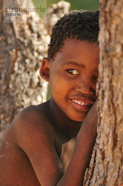 Hochformat  Portrait  Landschaft  verstecken  lächeln  Junge - Person  Namibia  Jagd  primitiv  Afrika  Nomade  Volksstamm  Stamm