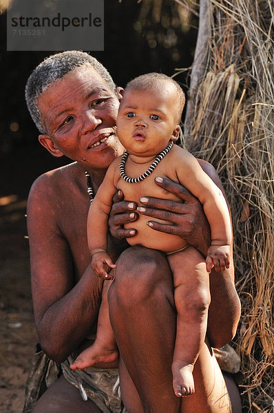 Hochformat  Frau  Landschaft  Großmutter  Säuglingsalter  Säugling  Namibia  Jagd  primitiv  Mutter - Mensch  Afrika  Baby  Nomade  Volksstamm  Stamm