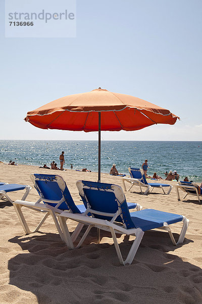 Liegen und Sonnenschirm am Strand  Calella de la Costa  Costa del Maresme  Katalonien  Spanien  Europa  ÖffentlicherGrund