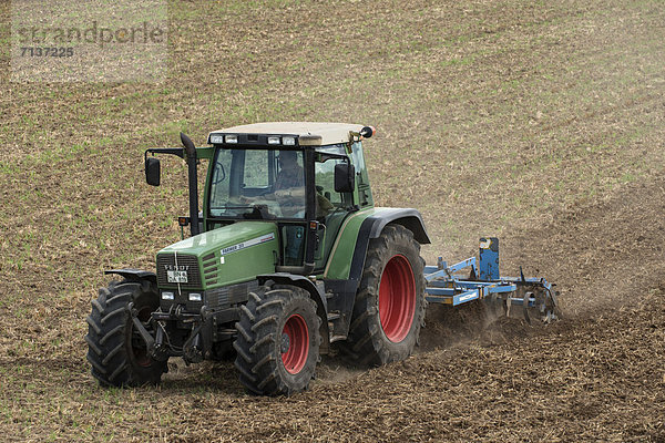 Traktor mit Grubber auf Acker  Deutschland  Europa  öffentlicherGrund