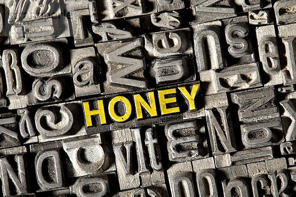 'Alte Bleilettern bilden das englische Wort ''HONEY'''