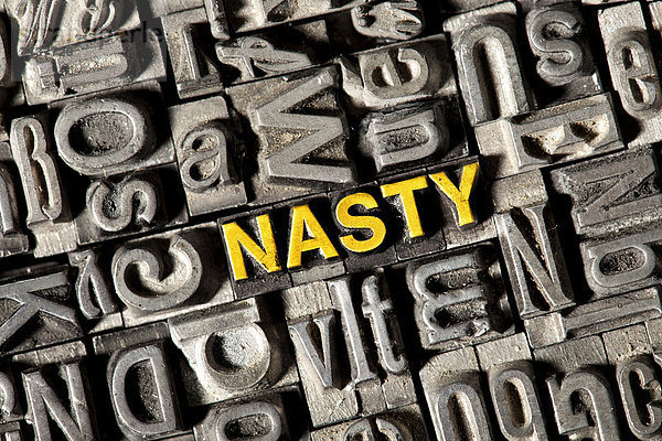 'Alte Bleilettern bilden das englische Wort ''NASTY'''