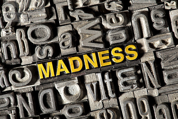 'Alte Bleilettern bilden das englische Wort ''MADNESS'''