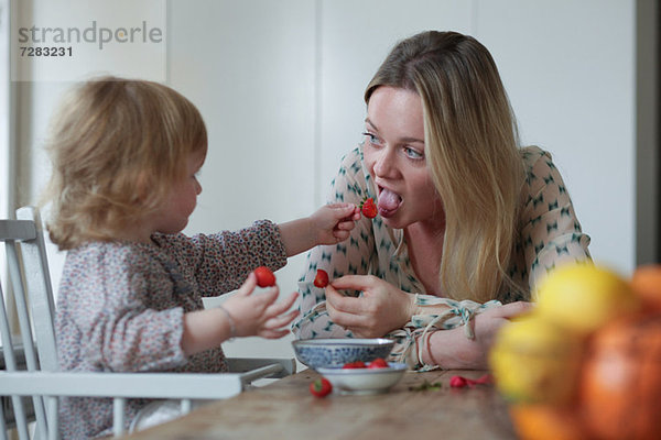 Tochter füttert Mutter Erdbeeren