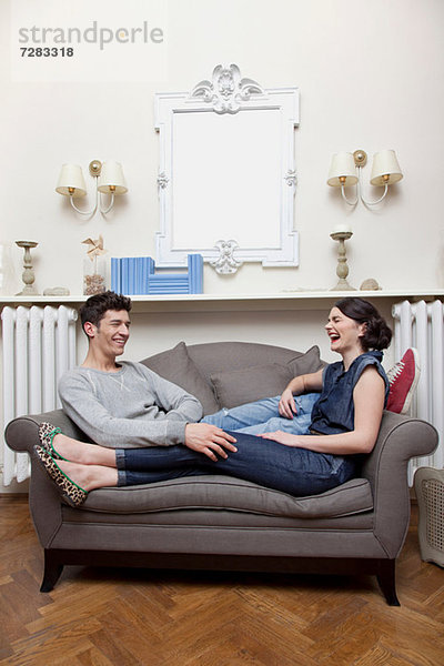 Paar lachend auf dem Sofa
