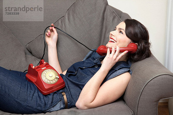 Frau auf dem Sofa am Telefon