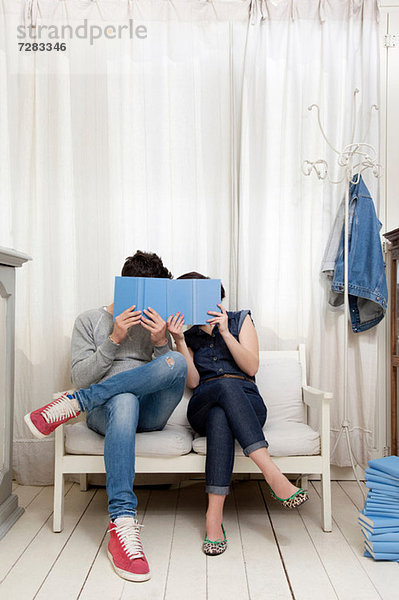 Paar versteckt sich hinter Büchern