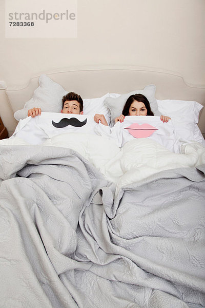 Paar im Bett mit Lippen und Schnurrbart Mund