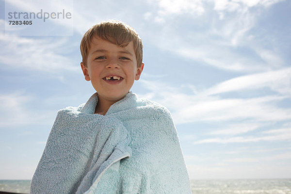 Junge am Meer  in ein Handtuch gewickelt