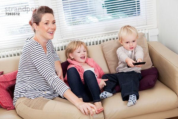 Mutter mit zwei Kindern beim Fernsehen