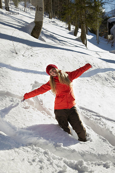 Porträt einer Frau mit rotem Mantel im Schnee  Arme ausgestreckt