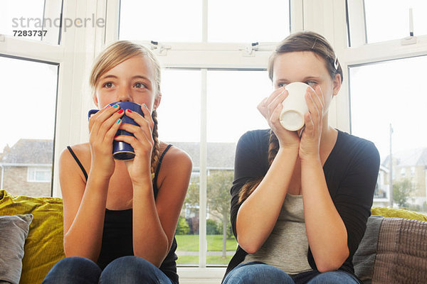 Zwei Mädchen trinken heiße Getränke