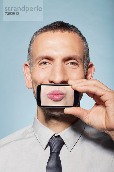Mann bedeckt Mund mit Smartphone  Mund