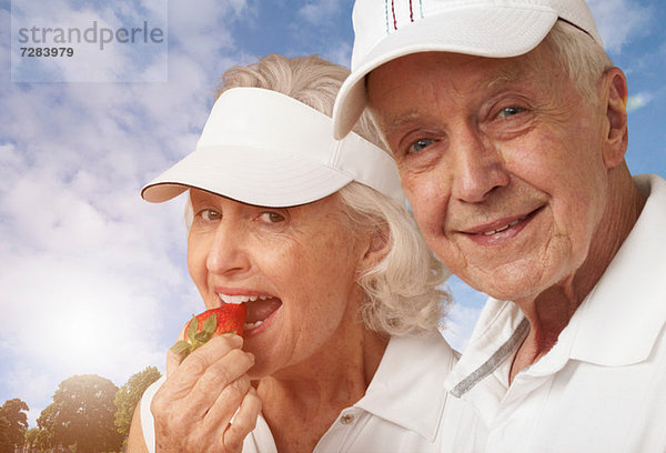 Senioren-Tennis-Pärchen essen Erdbeeren