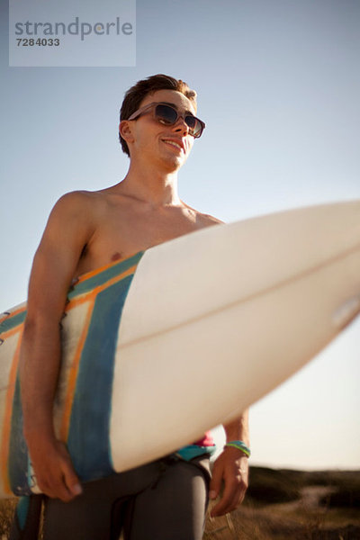 Junger Mann mit Surfbrett