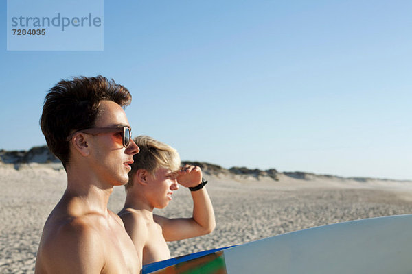 Zwei junge Surfer auf dem Weg zum Meer