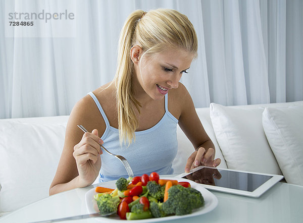 Frau mit Tablet-Computer und Essen