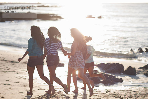 Frauen beim gemeinsamen Laufen am Strand