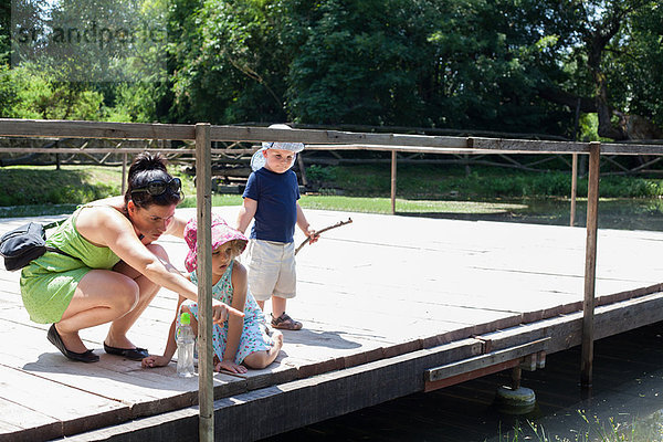 Mutter und Kinder untersuchen den Fluss