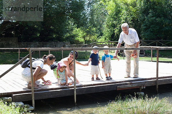 Familie untersucht Fluss auf der Brücke