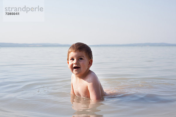 Junge spielt im Wasser im Freien