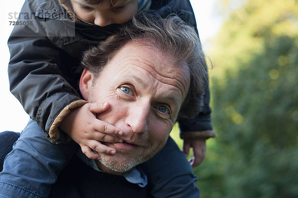 Vater trägt Sohn auf den Schultern