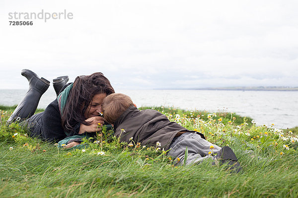 Mutter und Sohn liegen auf einer Wiese.