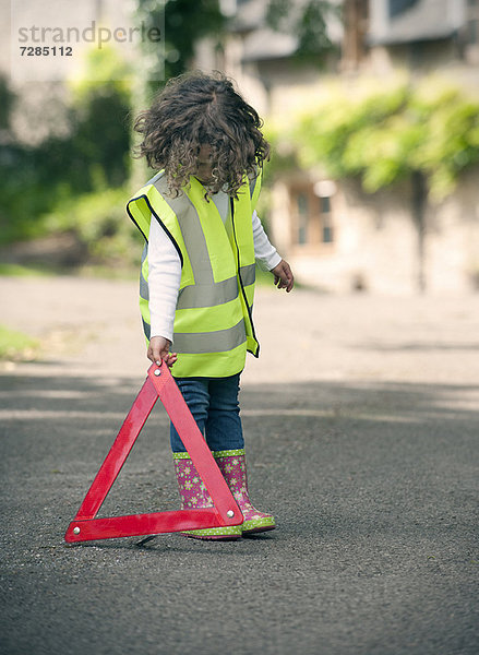 Mädchen spielt Verkehrsarbeiter auf der Landstraße