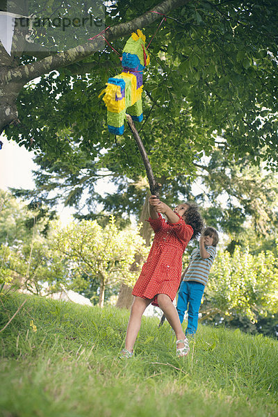 Mädchen schwingt bei pinata auf der Party