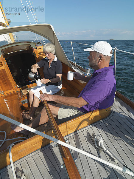 Ältere Paare segeln zusammen auf dem Meer