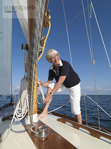 Frau beim Einstellen der Takelage auf dem Segelboot