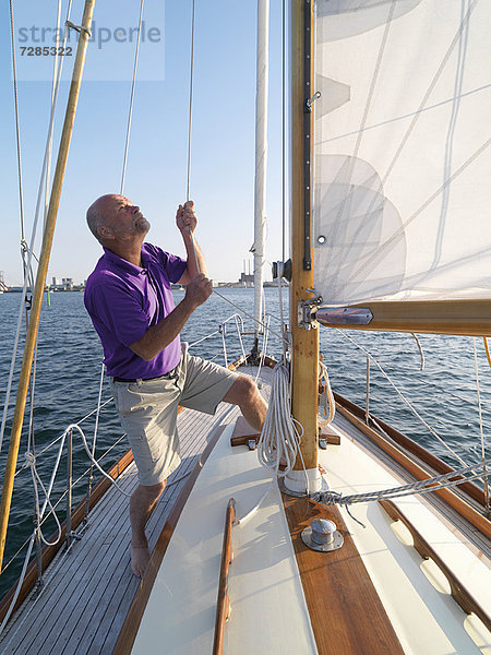 Mann beim Einstellen der Takelage auf dem Segelboot