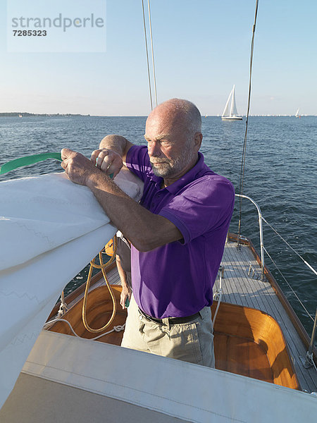 Mann beim Einstellen der Takelage auf dem Segelboot