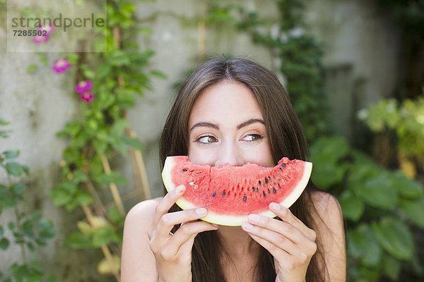 Lächelnde Frau spielt mit Wassermelone